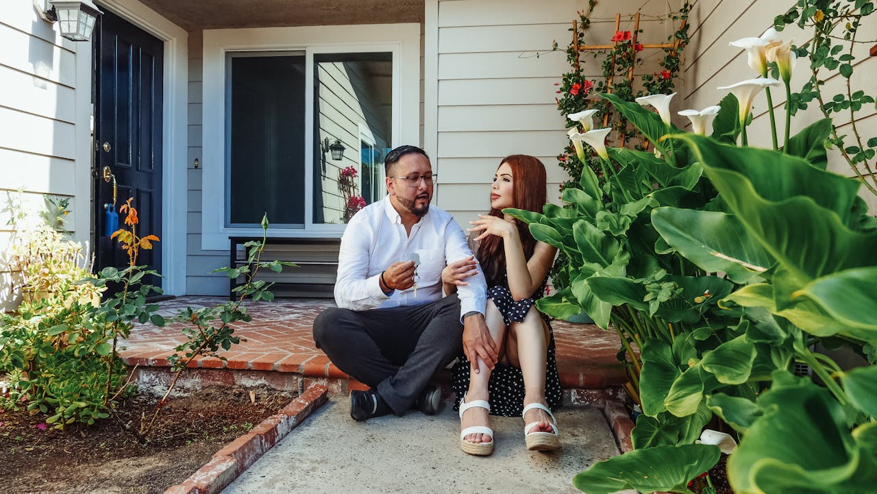 Homeowner sitting on a front porch with a coffee, reflecting on selling the house